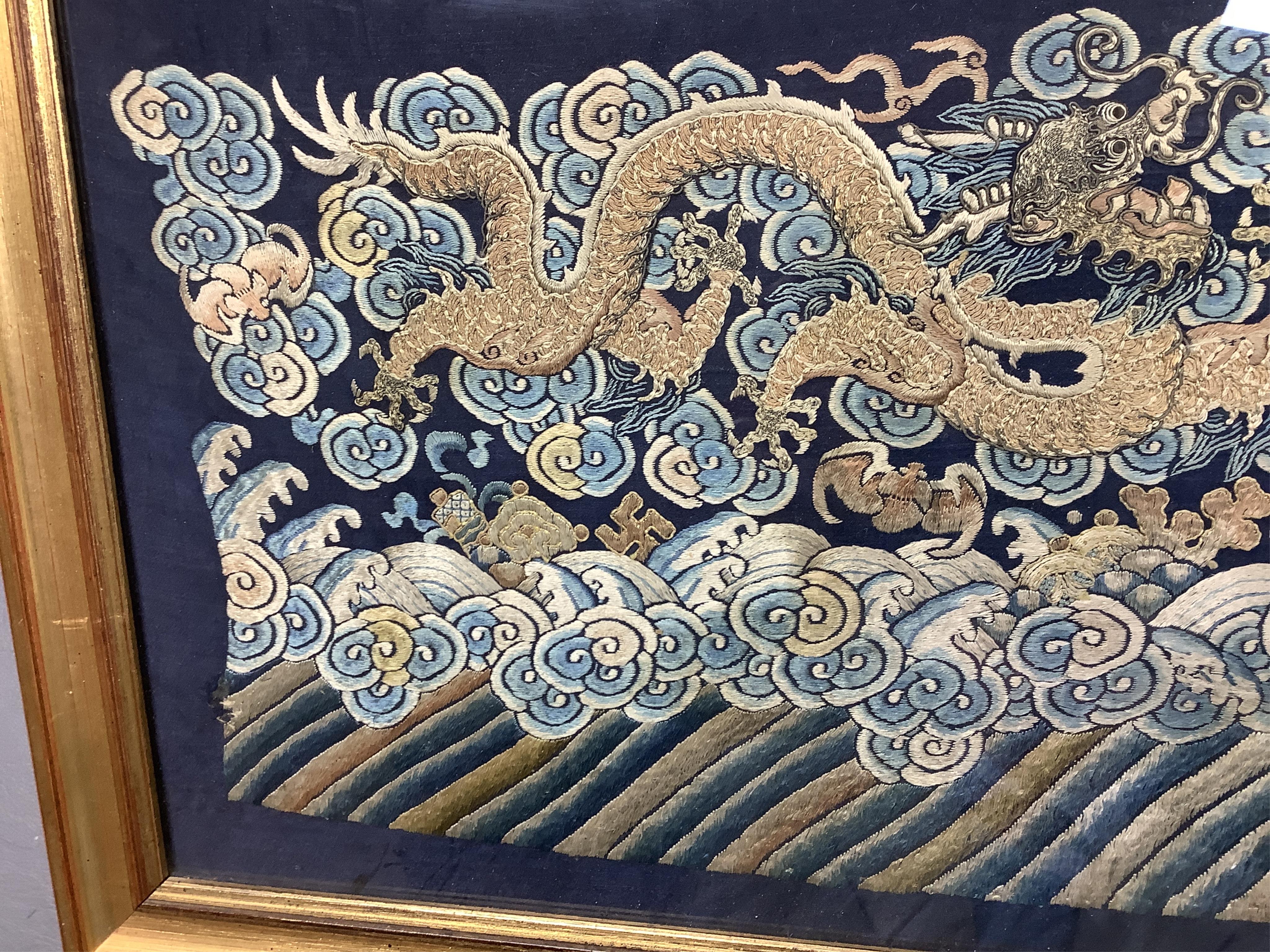 A framed late 19th / early 20th century Chinese silk embroidered five claw dragon panel from the base of a robe, 59cm wide x 23cm high. Condition - good, colours and embroidery strong
